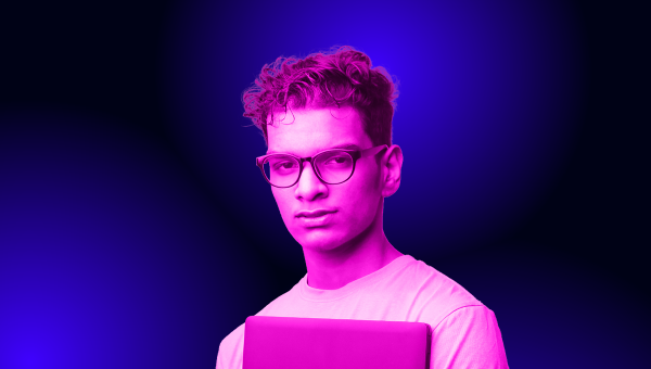 Young man with glasses holding a laptop